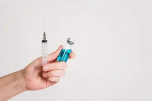 hand holding a syring and vial for what is rational use of antibiotics
