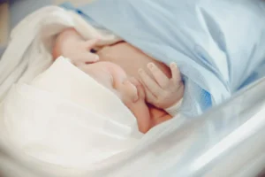 a newborn sleeping on a bed