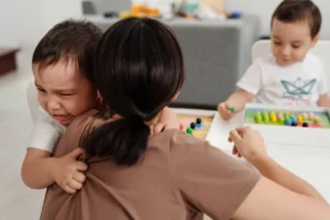 A mother console her child who is crying due to tantrums