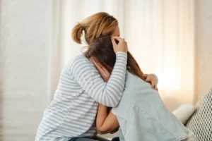 A mother comforting her crying daughter