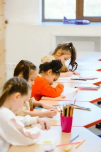 Children making painting in a classroom