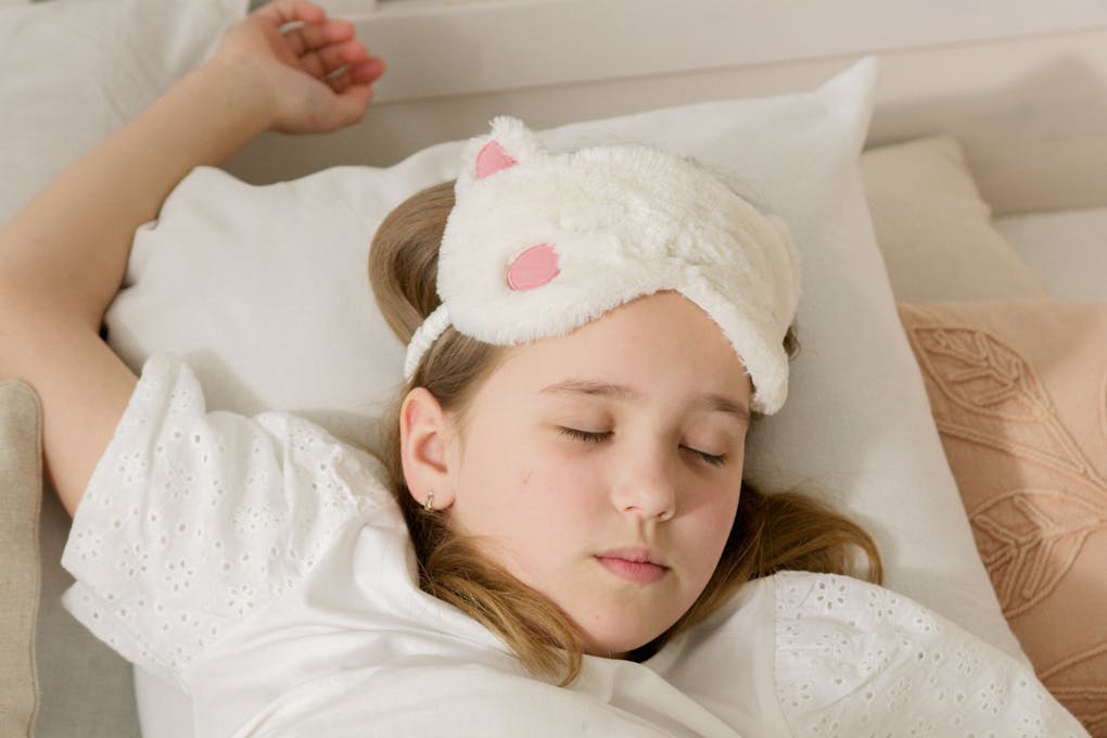 a girl sleeping peacefully on white bed