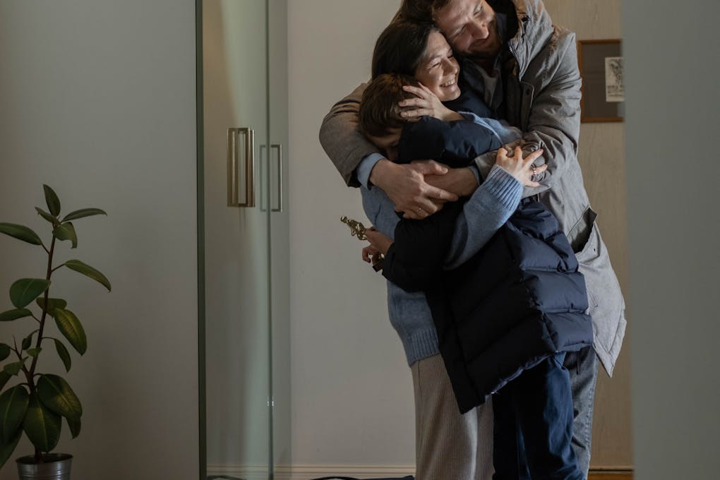 a teenage boy huging his parents
