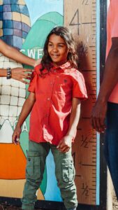 A girl standing near wall scale to measure her height