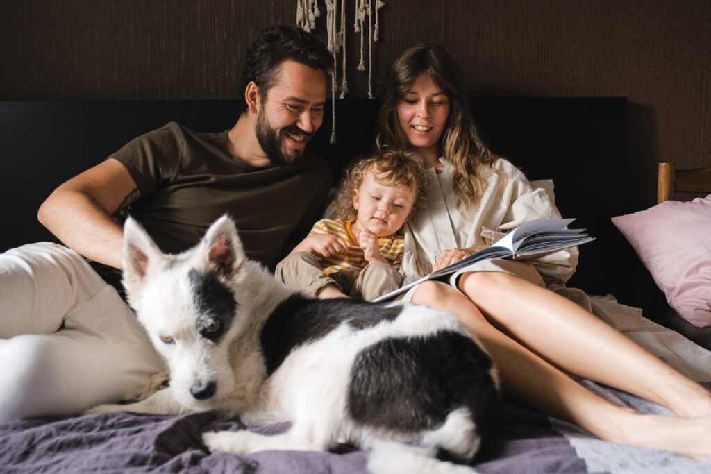 a father and mother reading a book their doughter showing• Childhood Development Tips in Hindi (Hindi Mein Bachpan Ke Vikas Ke Tips)