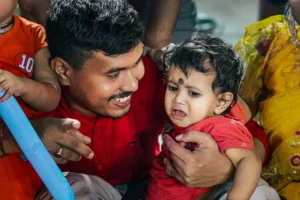 Father comforting crying baby during family gathering