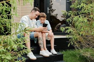 a father and his teenage son checking phone