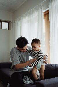a father chainging a diaper of his child