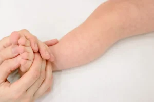 mother massaging her newborn baby feet with oil