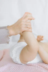 a newborn in a diaper sleeping on pink bed