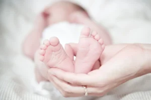 a newborn legs in mother hands close up