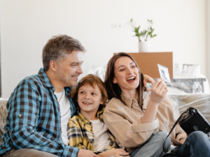 parents have a happy time with his son sitting together on sofa