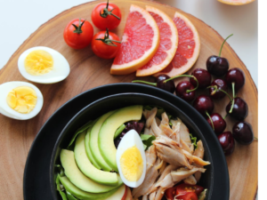 healthy food fruits,vegetables,egg meat all served in a plate and table